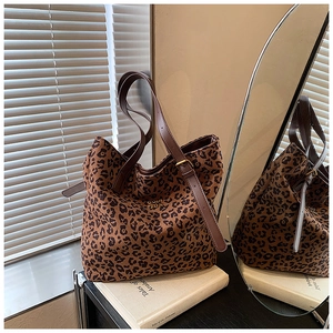 Detailed close-up of leopard print tote bag with adjustable leather straps and gold logo