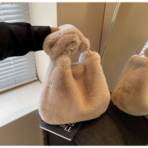 Détail du sac beige en peluche avec poignée en anneau doré et garniture en fausse fourrure