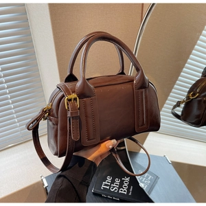 Dettaglio della borsa Boston vintage marrone scuro con pelle cerata e finiture dorate
