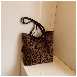 Macro detail of leopard print tote bag with gold logo and adjustable brown straps
