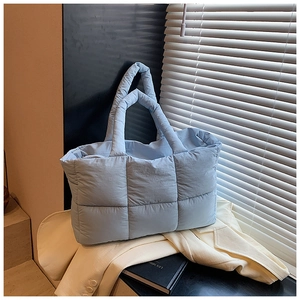 Close-up van de lichtblauwe gewatteerde tote bag met klassiek ruitpatroon en zachte vulling