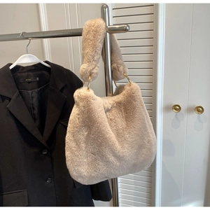 Détail du sac à bandoulière en fausse fourrure avec anneaux dorés et texture d'hiver