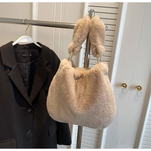 Détail d'un sac à main en fausse fourrure avec poignée souple et anneaux dorés