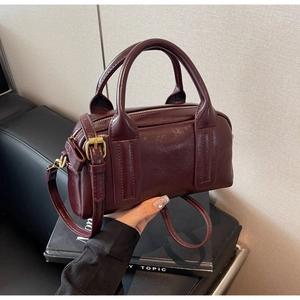 Vista dettagliata della borsa Boston rosso vino con pelle sintetica lucida e metallo oro