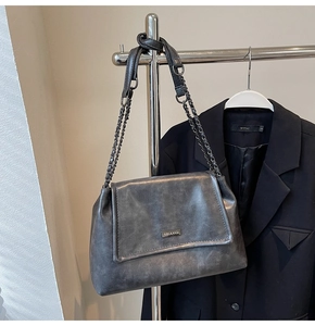 Détail du sac cabas gris vintage avec logo métallique et bandoulière en chaîne