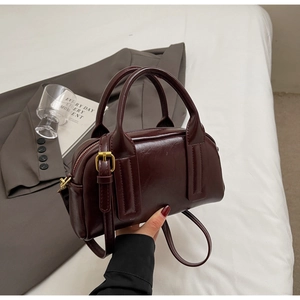 Nahaufnahme der burgunderroten Boston-Tasche aus glänzendem PU-Leder mit Metallreißverschluss