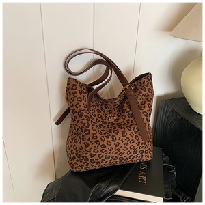 Close-up of leopard print tote bag with premium metal logo and brown leather handles