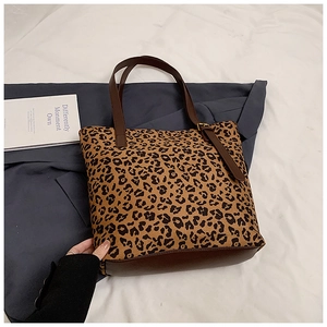 Detail of adjustable leather handles and gold buckle on leopard print tote bag