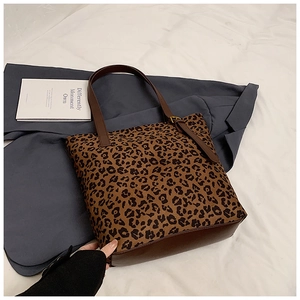 Detail of leopard print tote bag with brown leather straps and adjustable buckle detail