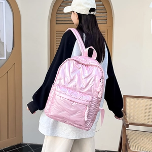 Detail der rosa gesteppten Metalltextur und des gewebten Reißverschlusses an dem Rucksack
