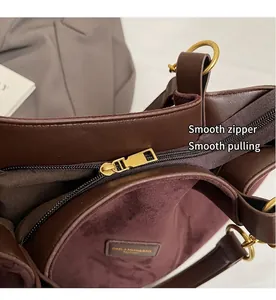 Detailed macro view of smooth gold zipper and red suede lining of the tote bag