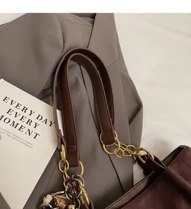 Detail view of large brown suede tote bag with stylish gold chain and leather handle