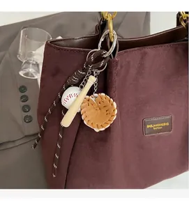 Close-up of sports style keychain with mini baseball bat and glove on a tote bag