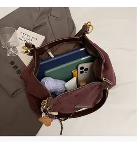 Spacious interior of brown suede tote bag showing daily essentials and tablet