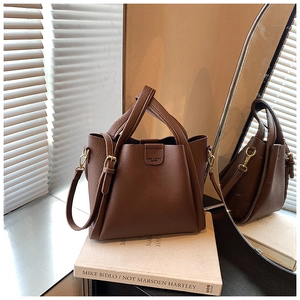Detail of dark brown pebble leather tote bag with magnetic flap closure and dual handles
