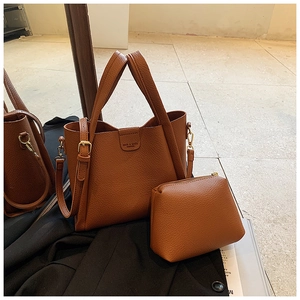 Detail of caramel textured leather tote with matching pouch and gold-tone hardware