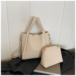 Close-up of cream lychee texture leather tote with matching zipper pouch and strap