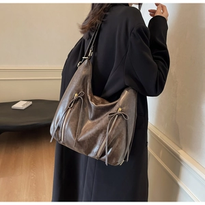 Detail of dark brown vintage Hobo bag with vertical zippers and elegant ribbons