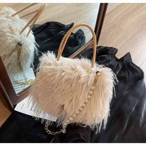 Detail of beige faux fur handbag featuring elegant pearl metal chain and dual handles