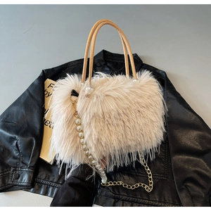 Detail of faux fox fur texture and elegant pearl handle on beige plush crossbody bag