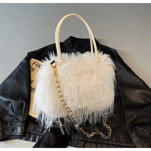 Detail of white faux fur bucket bag with pearl strap and gold metal chain link