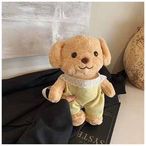 Detail of cute brown plush dog bag wearing yellow jumpsuit on a minimalist artistic background