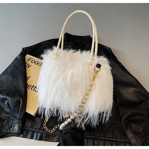 Macro detail of white faux fur handbag featuring pearl accents and a gold chain strap