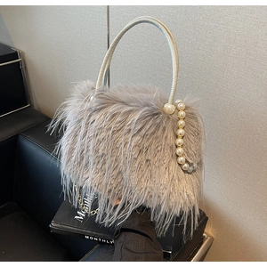 Close-up of plush grey faux fur handbag featuring elegant pearl bead chain and silver handle