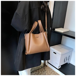 Close-up of brown pebbled leather texture on bucket bag with gold metal hardware