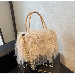 Detail of fluffy cream faux fur handbag with pearl strap and golden chain accent