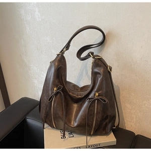 Close-up of dark brown vintage PU leather hobo bag with dual decorative vertical zippers