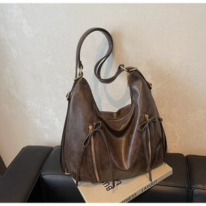 Detail of dark brown vintage faux leather tote bag with parallel zippers and hardware