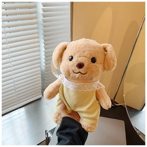 Detail of cute stuffed toy poodle wearing a yellow lace dress with soft khaki fur
