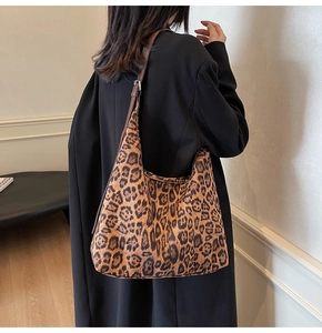 Détail de la bandoulière réglable en cuir marron et boucle argentée du sac léopard