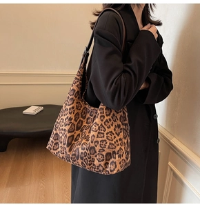 Gros plan d'un sac cabas léopard avec bandoulière en cuir brun et boucle en métal