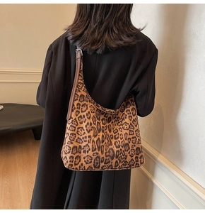 Vue détaillée d'un sac hobo à imprimé léopard porté avec un manteau d'hiver noir