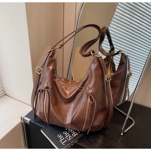 Detail of vintage oil wax leather tote bag with bow accents and mirror reflection view