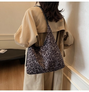 Détail du grand sac cabas à imprimé léopard porté par un mannequin en intérieur