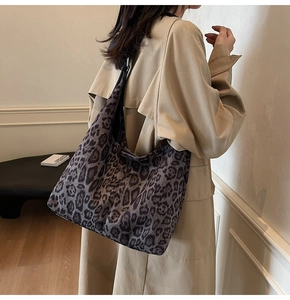 Gros plan d'un grand sac cabas à imprimé léopard porté avec un trench-coat moderne