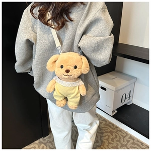 Close-up of yellow plush poodle crossbody bag worn by a model with a white strap