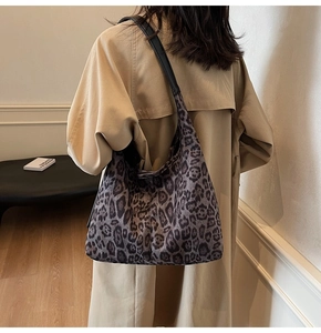 Détail d'un grand sac cabas léopard avec texture en fausse fourrure et bandoulière en cuir
