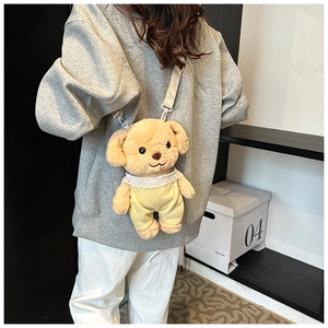 Rear view of model wearing a plush poodle crossbody bag with yellow overalls and lace trim