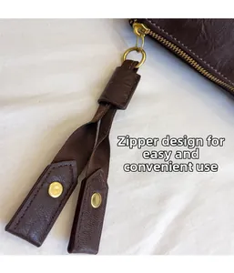 Detailed view of the easy-to-use golden metal zipper on a dark brown leather bag