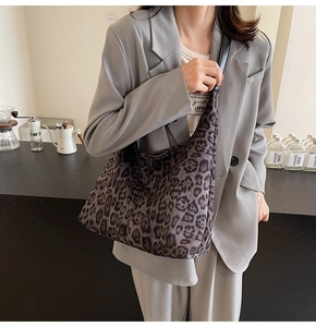 Gros plan du sac hobo léopard avec bandoulière en cuir noir et texture douce en tissu