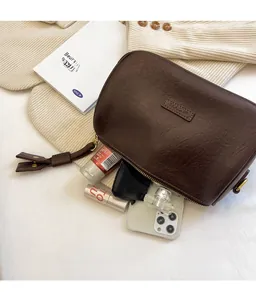 Deep brown vintage crossbody bag showing internal storage capacity with essentials