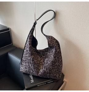 Détail du sac cabas à imprimé léopard avec bandoulière réglable en cuir noir durable