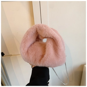 Détail du sac à main rose en fausse fourrure douce avec poignée nouée et chaîne argentée