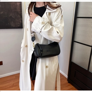 Detailed view of black pebbled leather pillow bag with stylish wide patterned shoulder strap