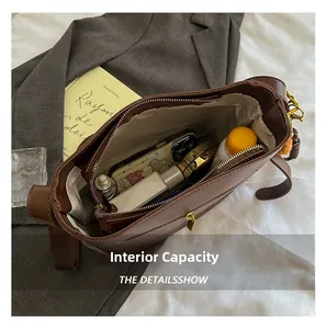 Détail de la capacité intérieure du sac à bandoulière marron vintage montrant le rangement