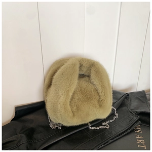 Détail d'un sac à main en fausse fourrure vert olive avec bandoulière chaîne argentée
